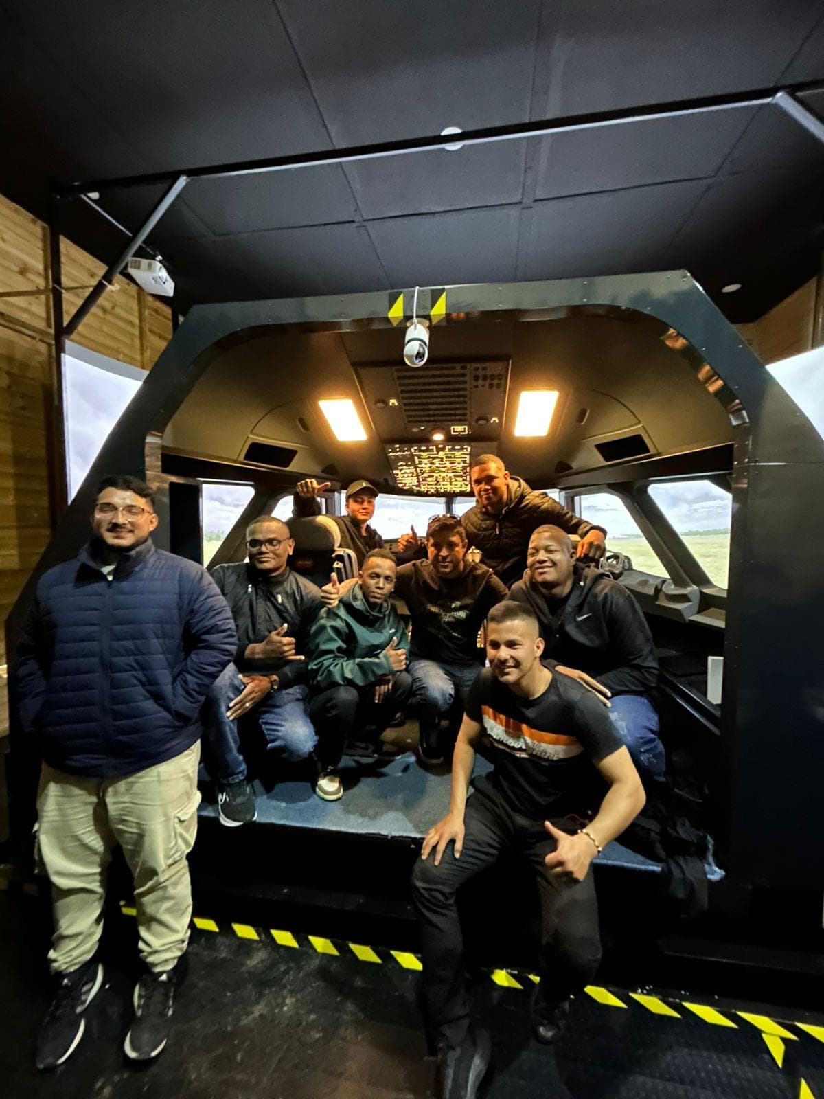 Training team in front of a full-flight simulator cockpit